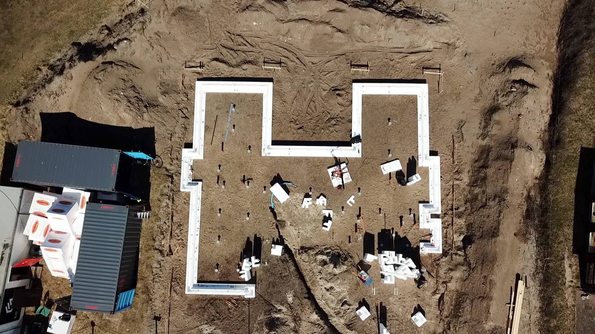 Dronefoto fra byggeri på blødjord i Klitmøller. Hvide funderingsblokke lyser op på den brune jord.