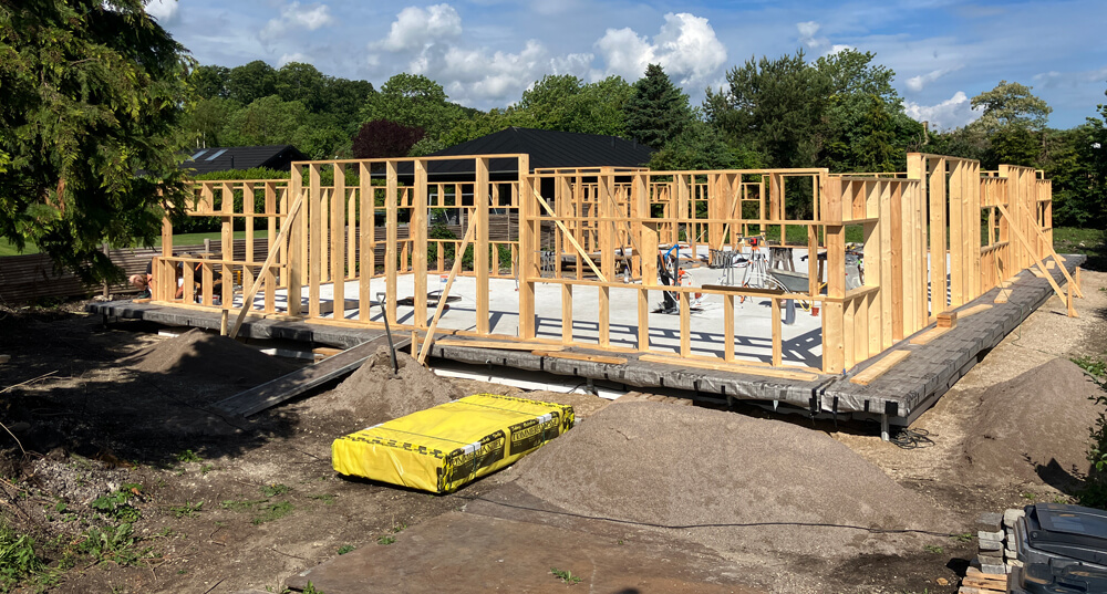 Byggeri på gammel mosegrund i Rungsted. Fundament og terrændæk er støbt, og nu er ydervæggene ved at blive rejst