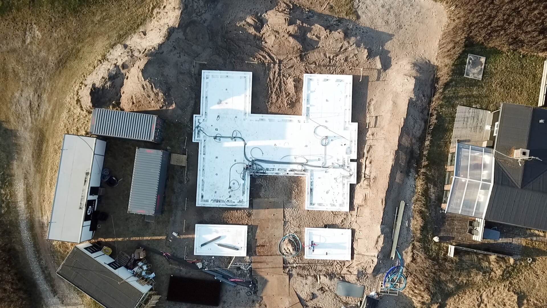 Dronefoto af fundering på blød jord i Klitmøller. Isolering er udlagt i det store H-formede fundament, som nu skal støbes